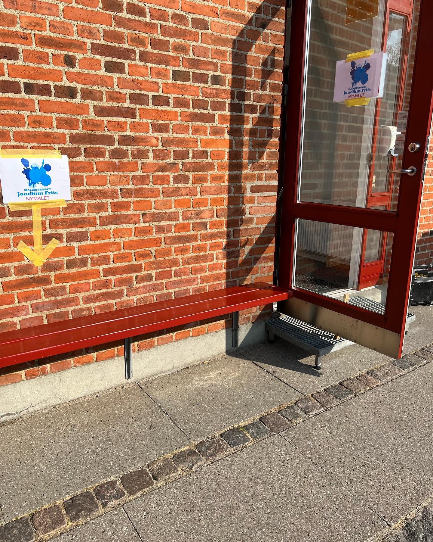 Rødmalet indgangsparti ved murstensbygning